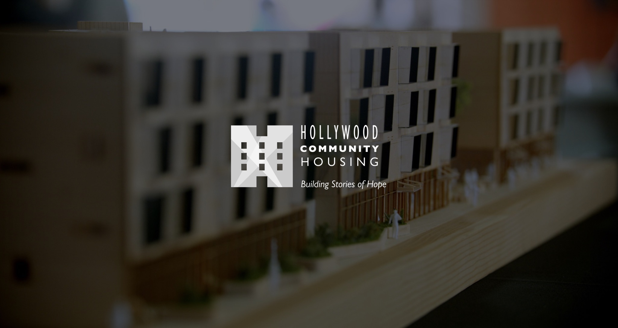 IU C&I Studios Page White Hollywood Community Housing Building Stories of Hope with dimmed background showing closeup of scale model of buildings on piece of wood