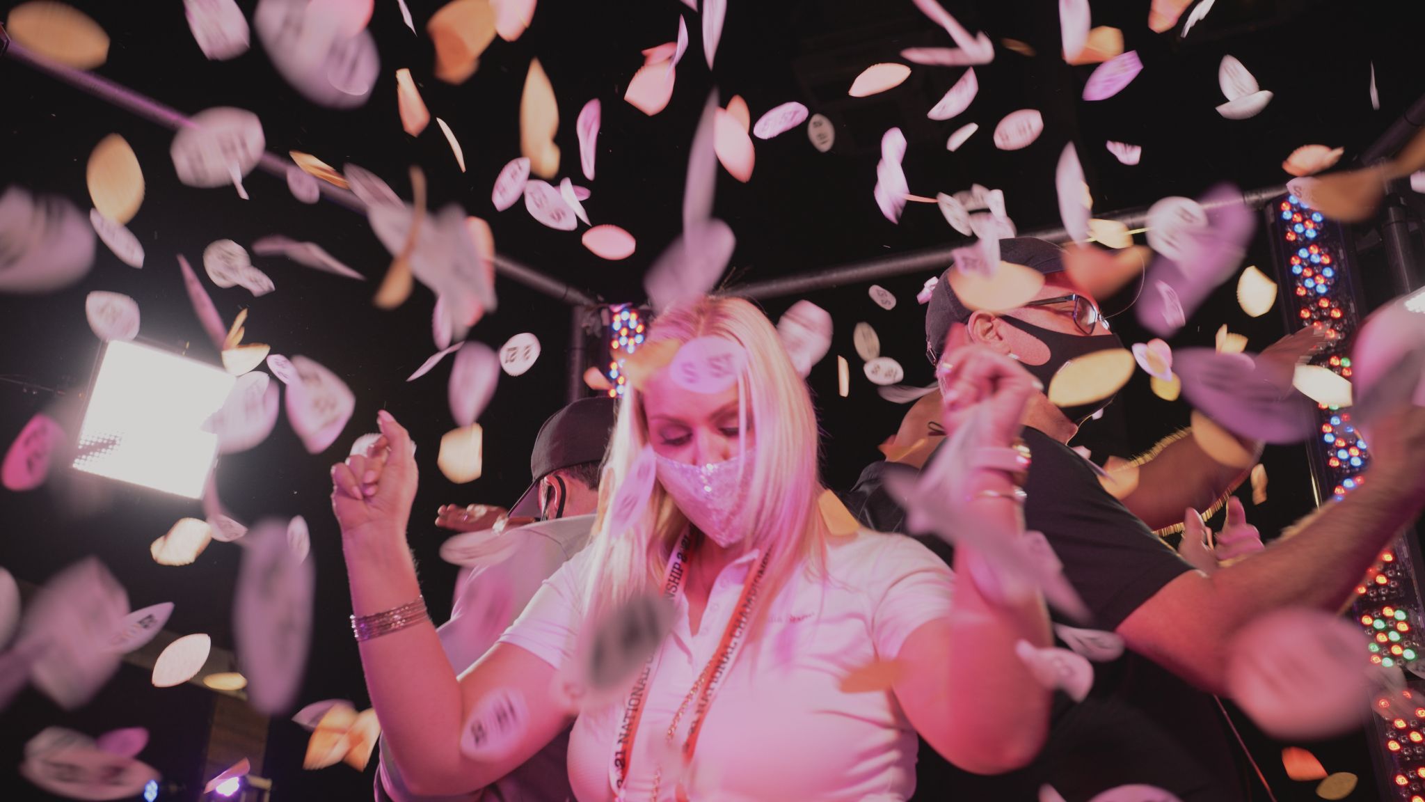 Where to Use a Brand Sizzle Woman with long blond hair wearing mask dancing among confetti with two male crew members behind her