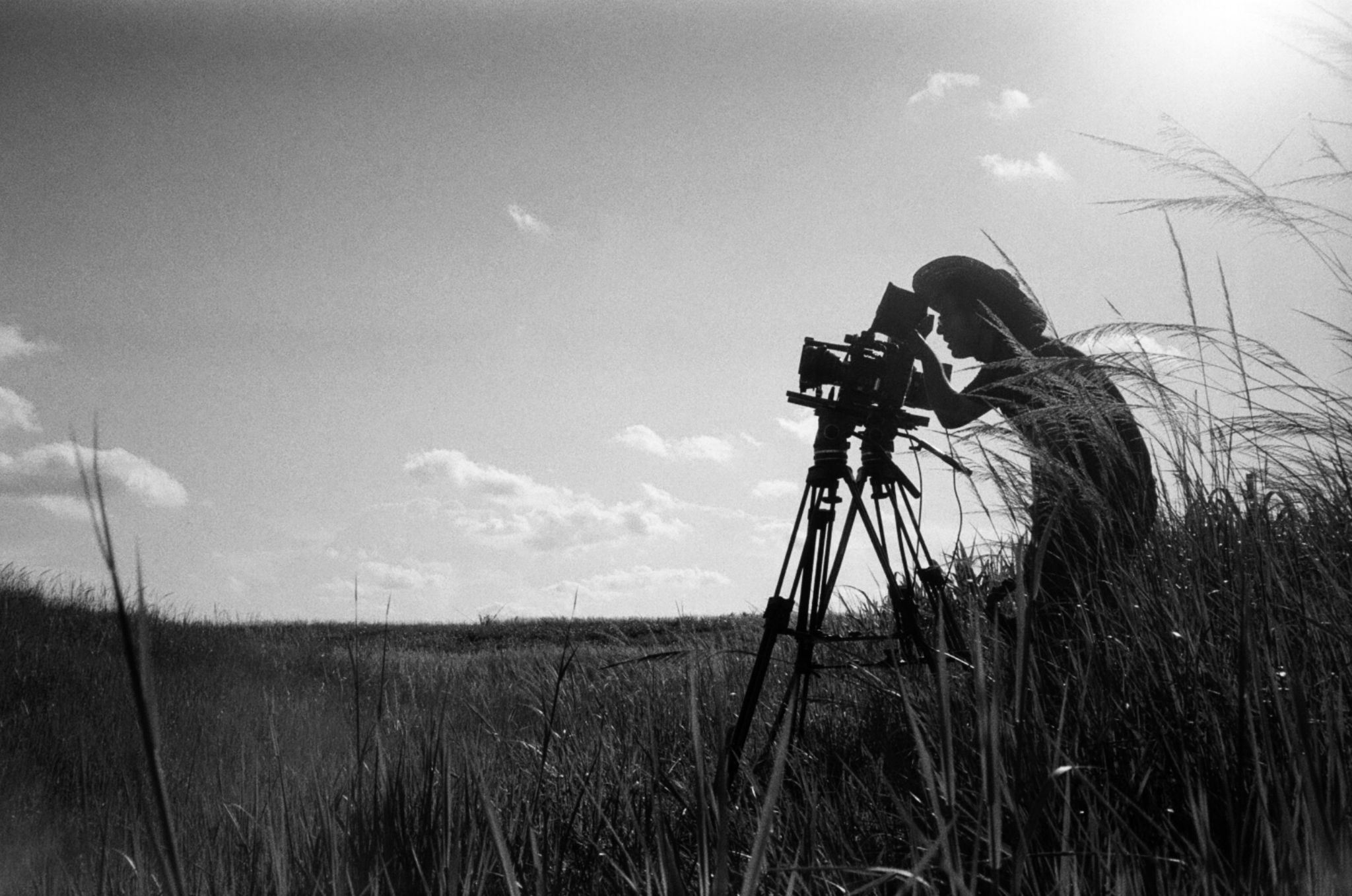 HD Cameras to Capture High Quality Film Footage and Where to Purchase Them Black and white side profile of male crew member using a video camera in a field