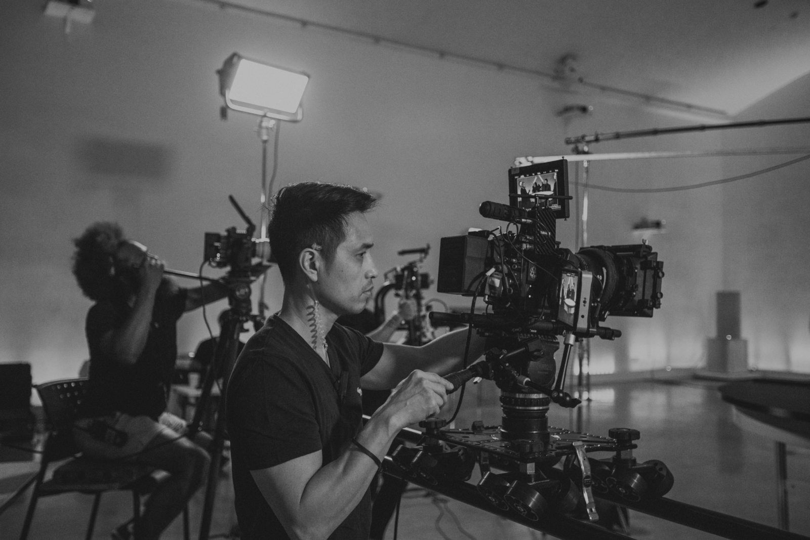 What makes a good camera operator Black and white side profile of two male crew members using video cameras