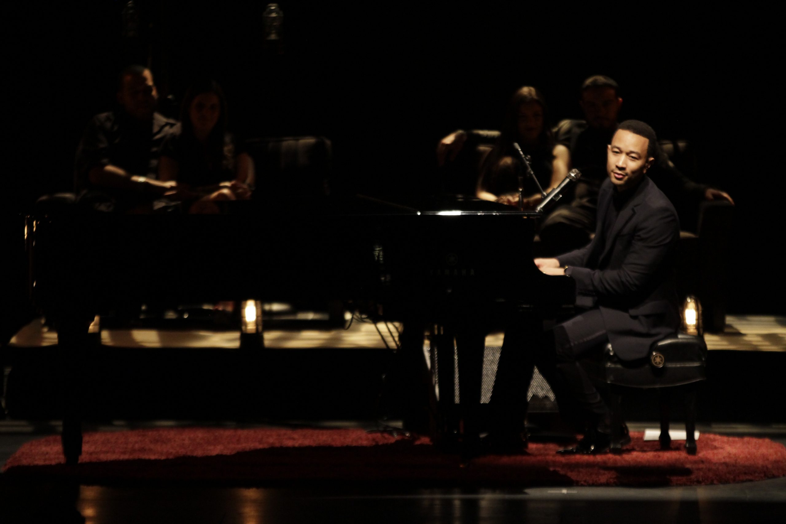 Side profile of John Legend performing in concert