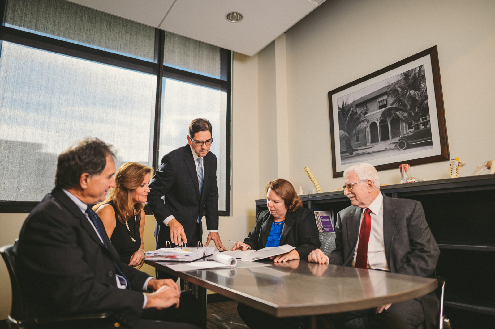 Three male and two female lawyers discussing a case in a conference room