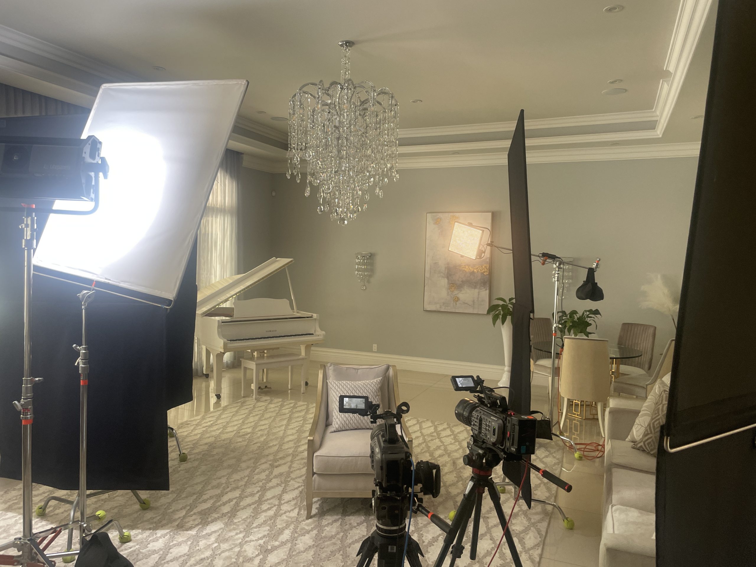 Documentary Production Company Key Components of a Documentary or Docuseries Two video cameras and lighting equipment on a set with chairs, table and white piano