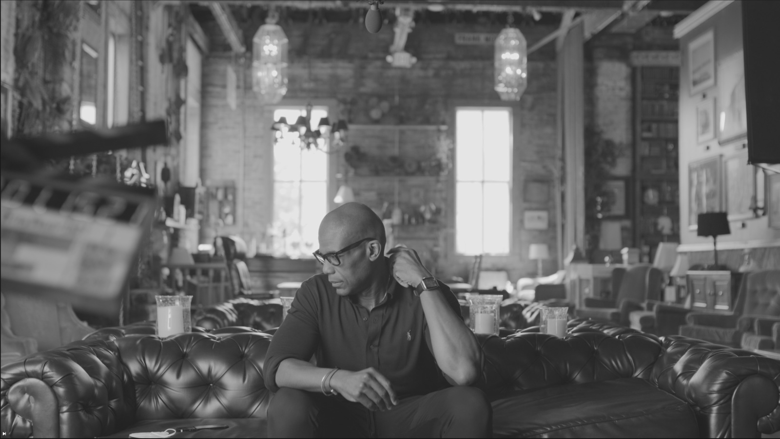 Step by Step Guide to Filming Your Pilot Black and white of African American man sitting on a leather couch looking off to the side