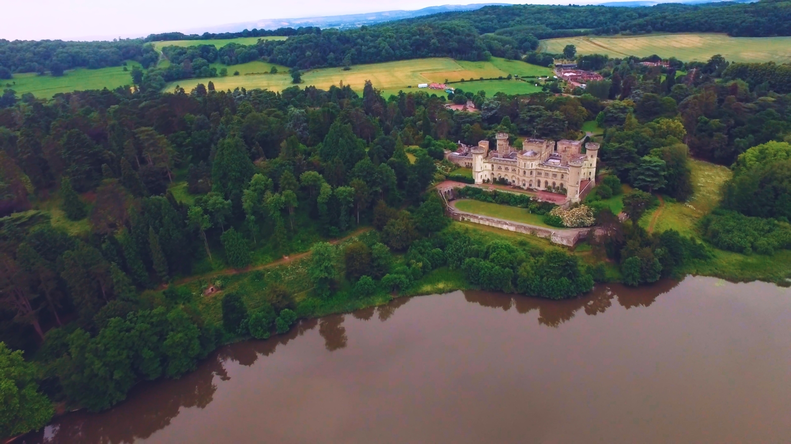The Benefits of Location Scouting for Film and TV Production Aerial view of a castle surrounded by forest by a lake