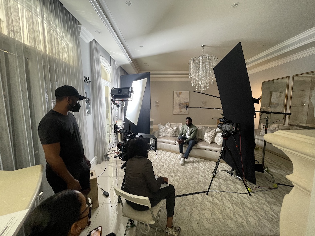BlackPopBTS Emmanuel Acho by CI Studios with him sitting surrounded by crew with equipment