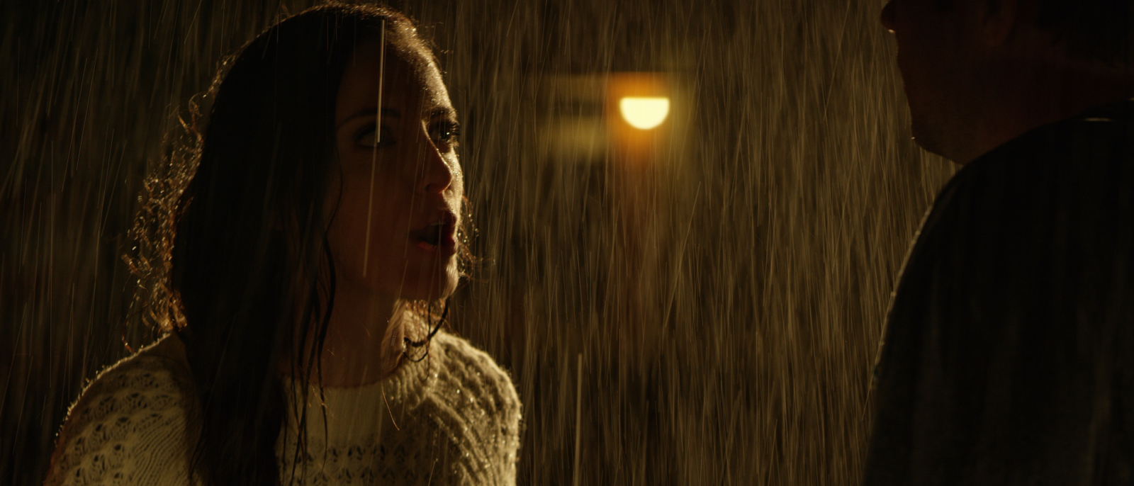 Color Correction Storytelling Screenshot from a movie of a woman with long hair talking in the rain to a man