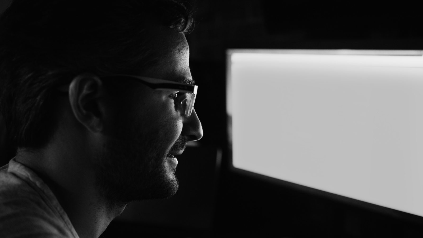 Black and white side profile of man working on a computer