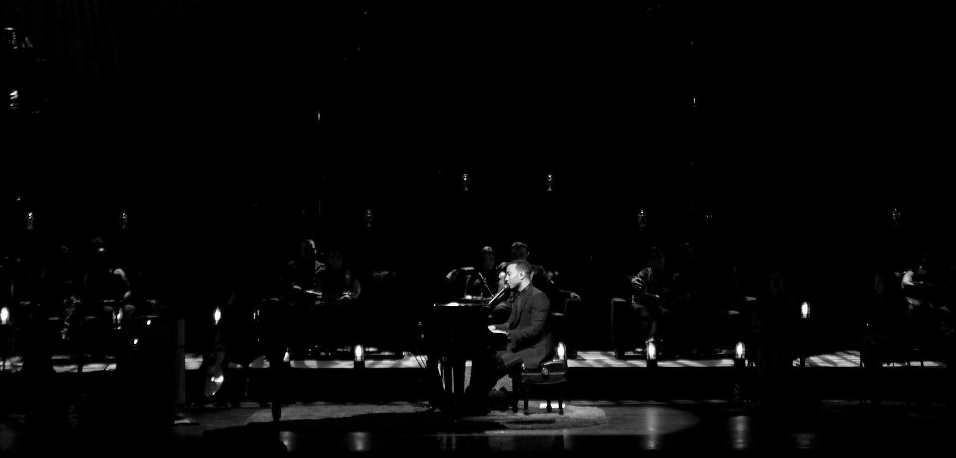 Black and white side profile of John Legend on stage