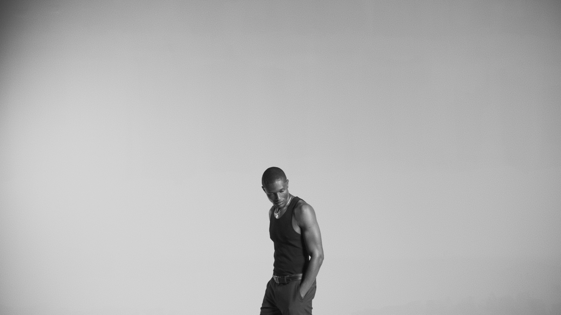 Black and white side profile of African American man wearing tank top looking slightly behind him
